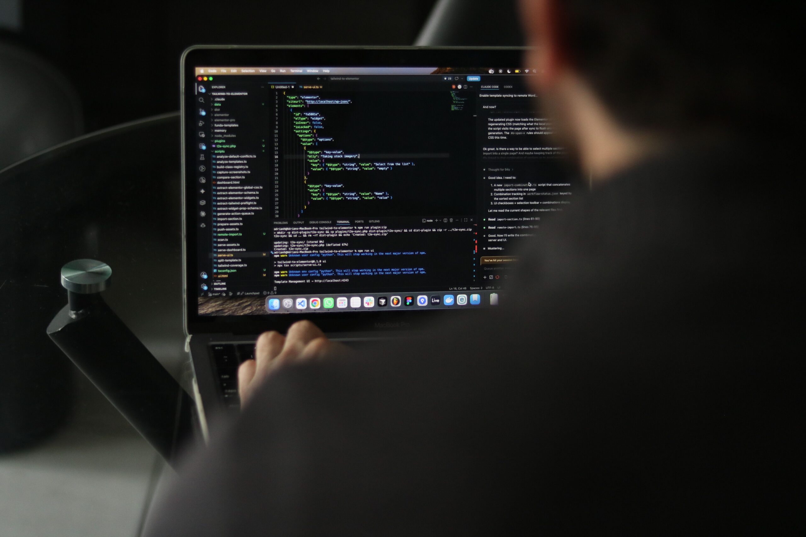 A focused developer writing code on a laptop in an indoor workspace.